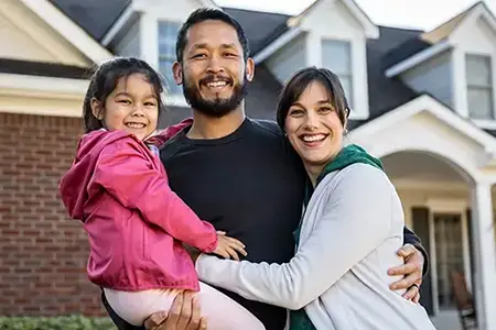 family in front of new home