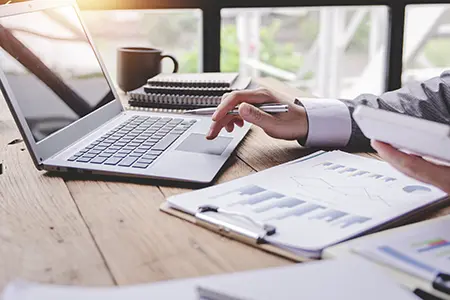 banking paperwork with person on a laptop